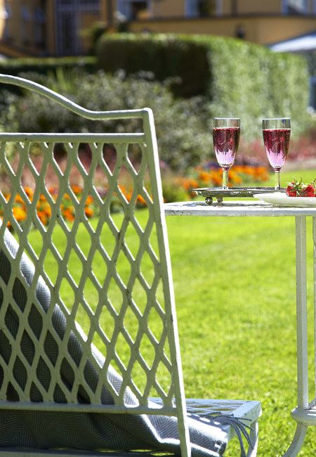 Close Up 2 Glasses Of Pink Champagne With Garden Chair